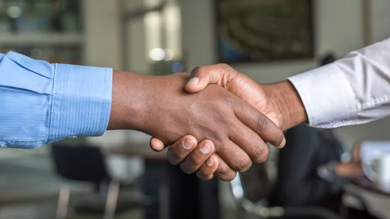 Two people shaking hands during a workplace discussion