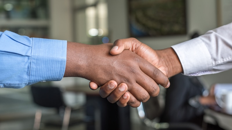 New migrant shaking hands with employer after successful job interview in Australia