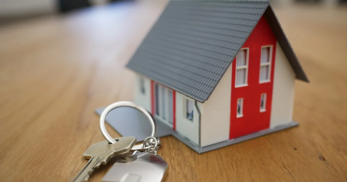 Miniature house model next to house keys representing renting or buying a home in Australia